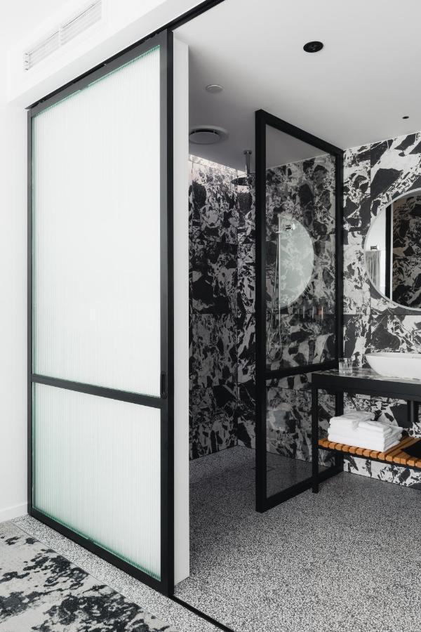 Ebb-Dunedin Buitenkant foto A shower enclosure with a frosted glass door