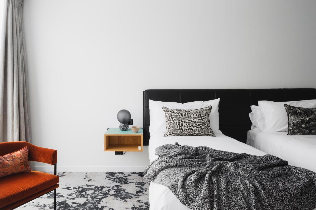Ebb-Dunedin Buitenkant foto A bedroom with a bed, a chair and a nightstand