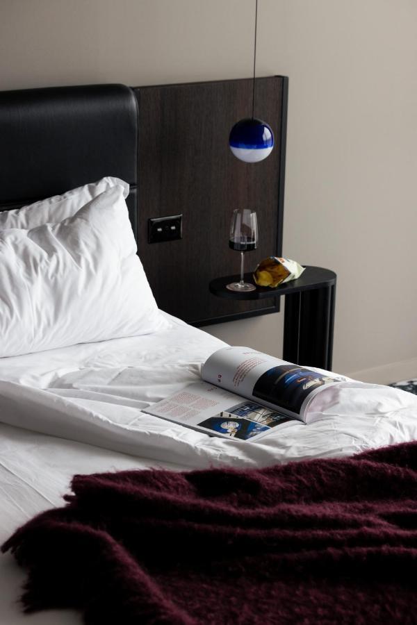 Ebb-Dunedin Buitenkant foto A bed with a magazine and a wine bottle